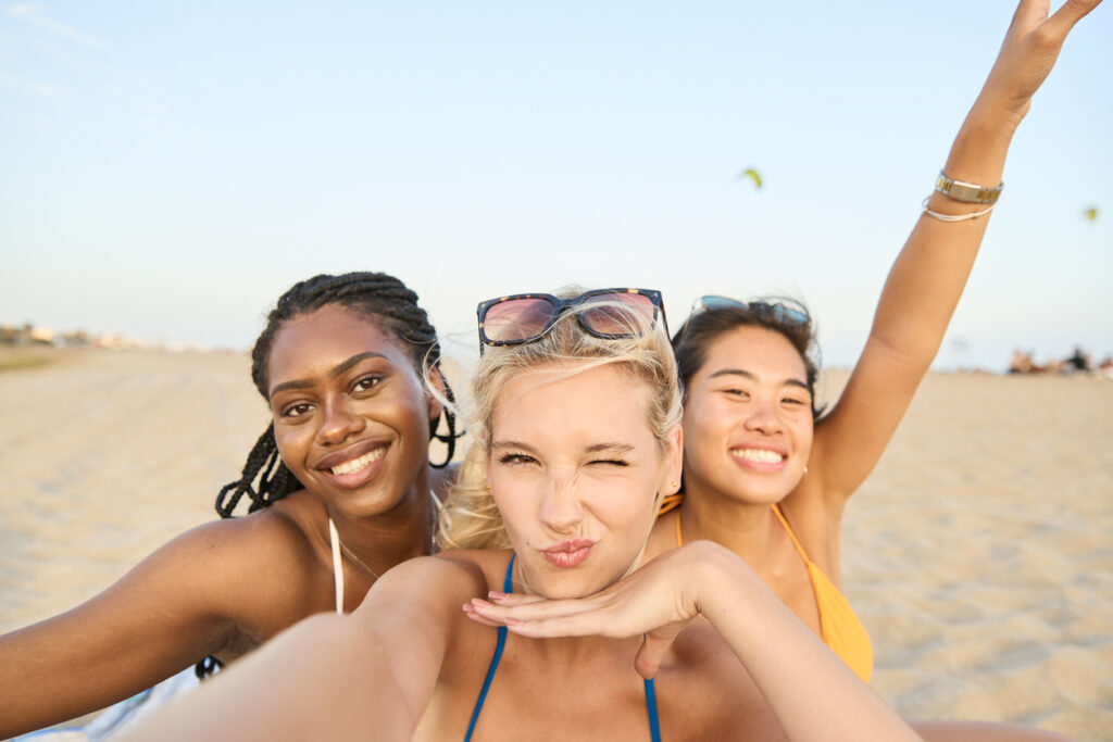 Group of 3 young happy women on the beach