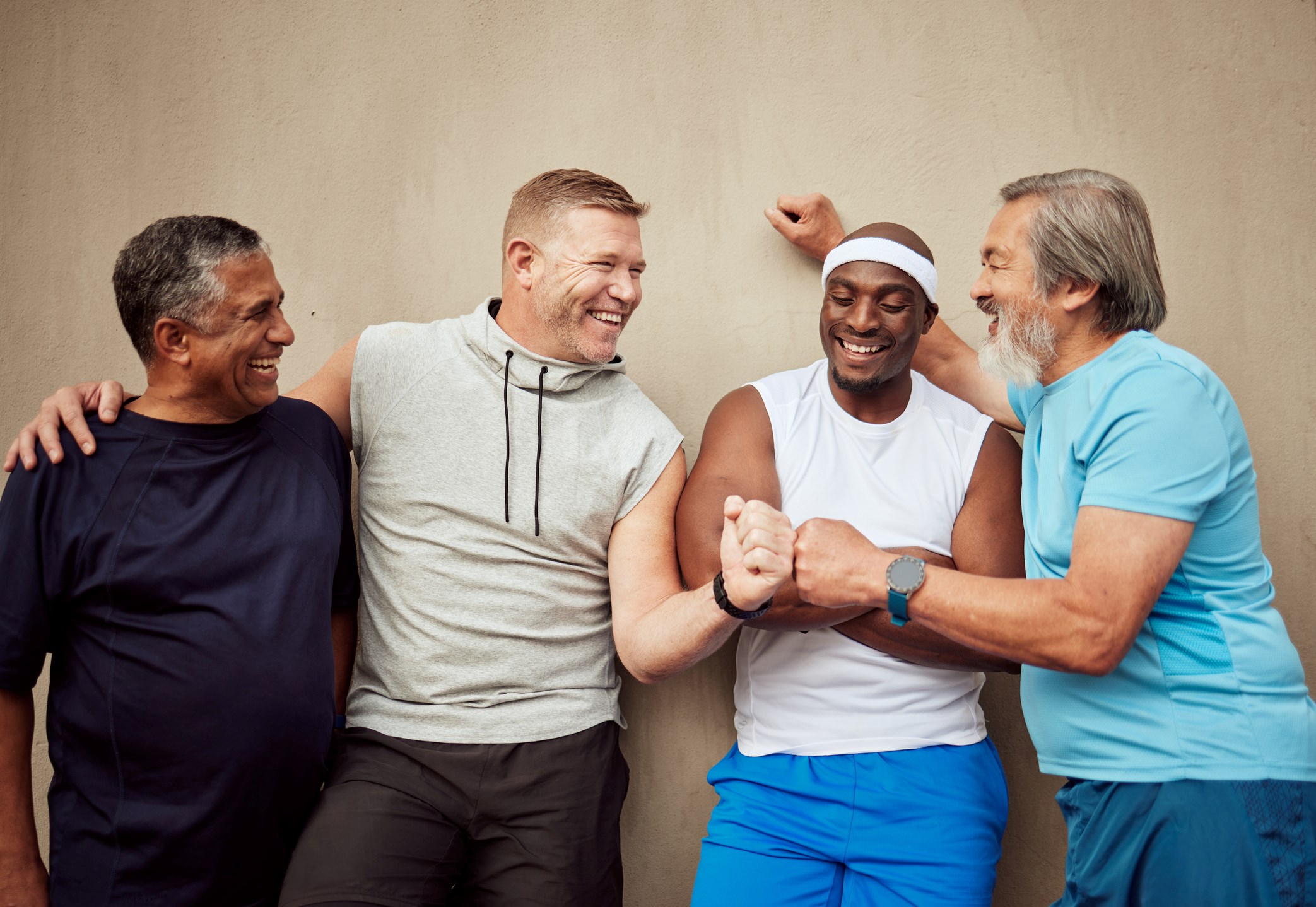 A group of mature fit looking men doing fist bumps