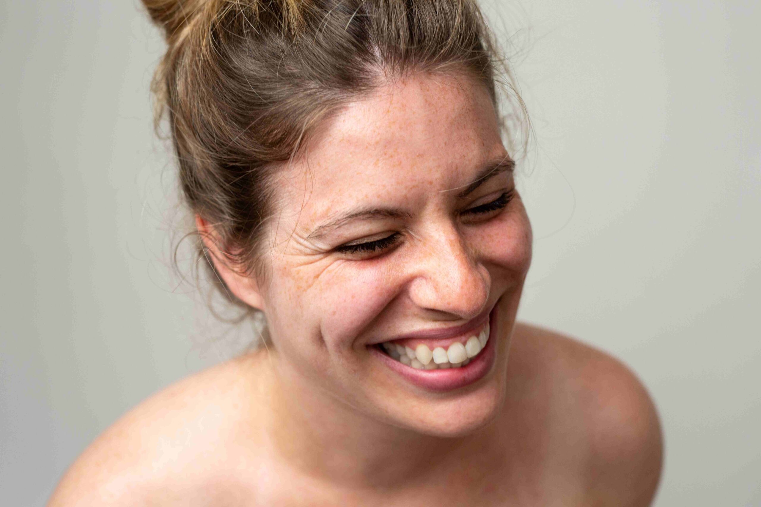 Woman with curly hair tied up in a bun happy smile